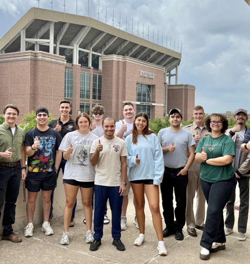 Group of CLUES students posing for a photo in front of Kyle Field