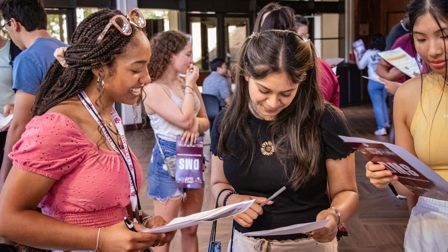 Three students engaging with each other at a DMS event